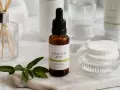 Serum z kwasem salicylowym na niedoskonałości skóry. W buteleczce z pipetą, obok wacików i gałązki.