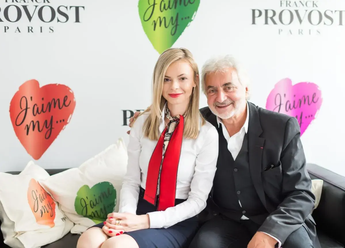 Franck Provost i uśmiechnięta kobieta siedzą na kanapie. W tle logo Franck Provost i serca z napisem "J'aime my...".