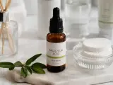 Serum z kwasem salicylowym na niedoskonałości skóry. W buteleczce z pipetą, obok wacików i gałązki.