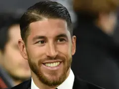 Sergio Ramos z charakterystycznym przedziałkiem z boku, uśmiecha się szeroko, prezentując zarost.